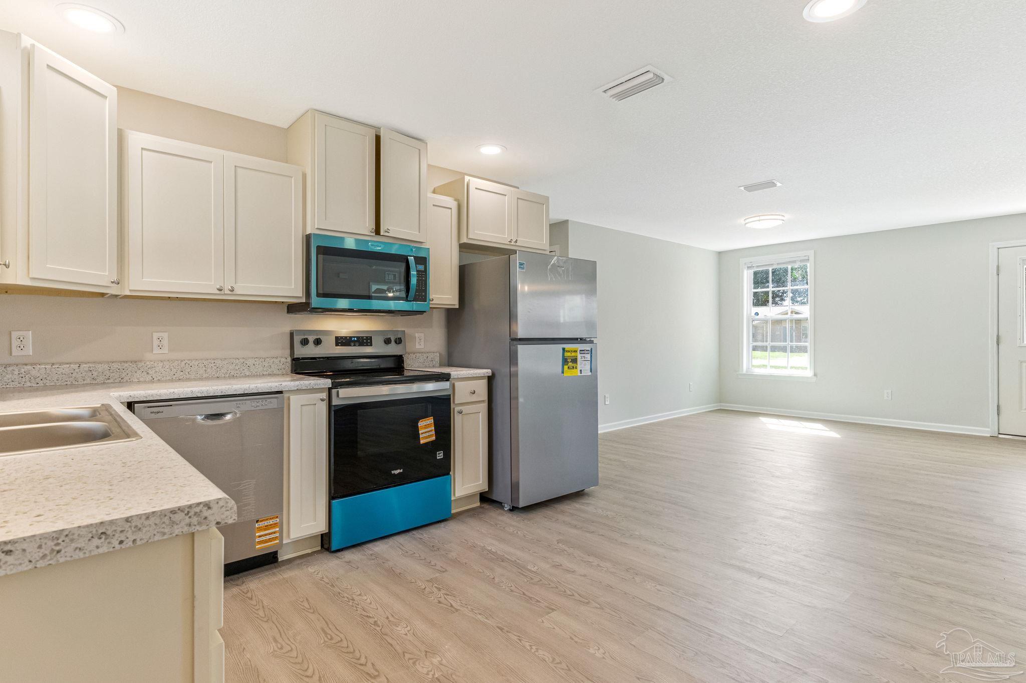 3152 Clemson Road Gulf Breeze, FL 32563 - Photo 7 of 56 a kitchen with granite countertop a refrigerator and a stove top oven