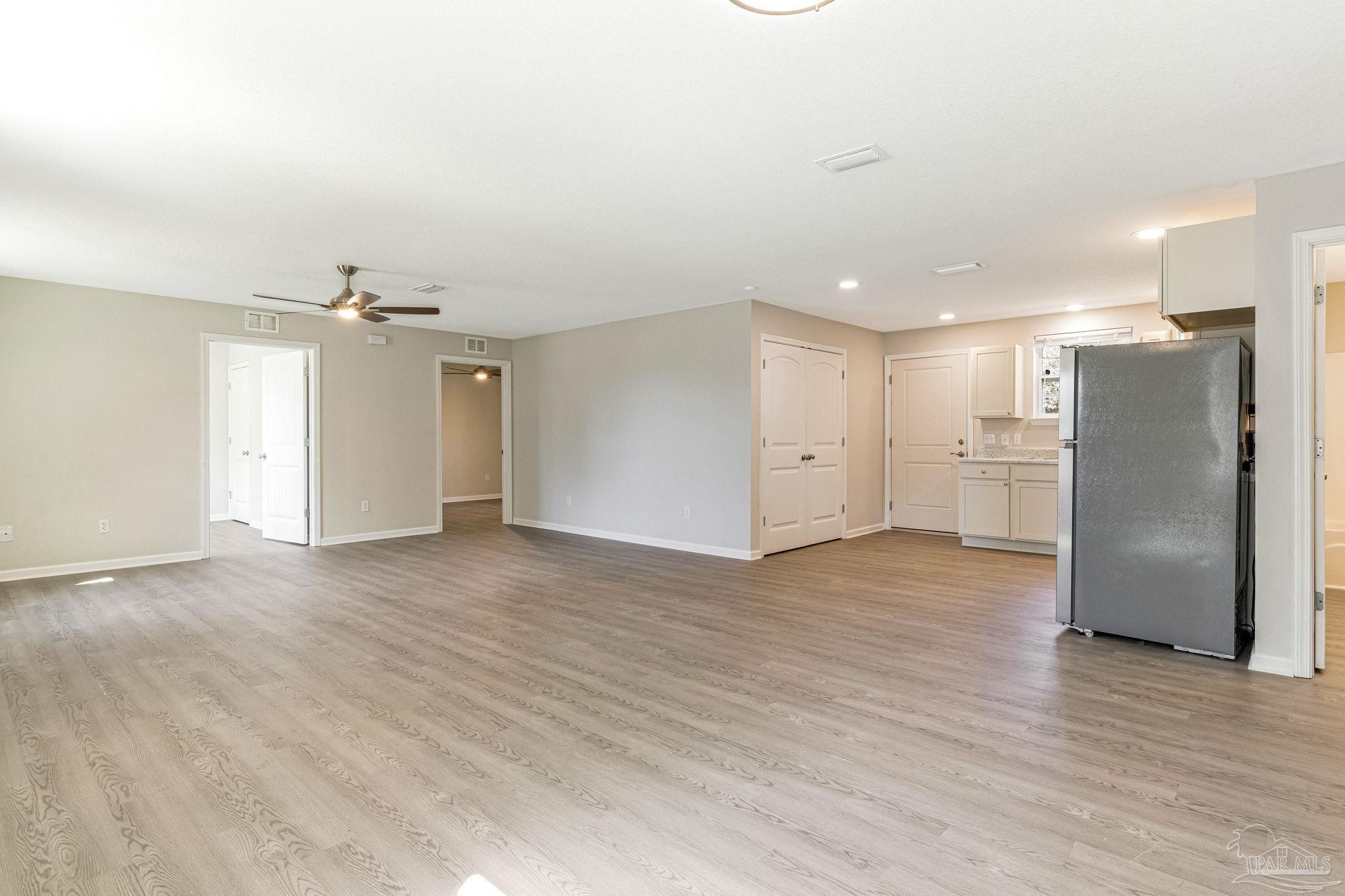 3152 Clemson Road Gulf Breeze, FL 32563 - Photo 8 of 56 wooden floor in an empty room with a kitchen