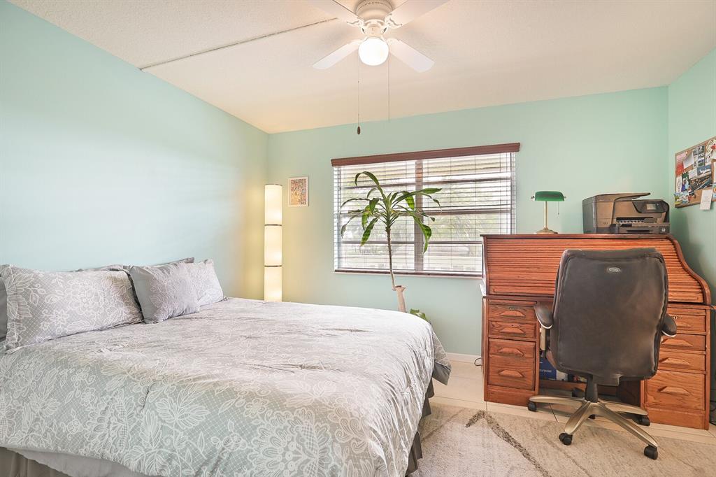 1141 Calamondin Terrace, Unit 202 Delray Beach, FL 33445 - Photo 11 of 19 a bedroom with a bed and a chair
