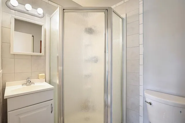 a bathroom with a shower sink and mirror