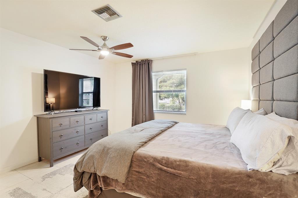 1141 Calamondin Terrace, Unit 202 Delray Beach, FL 33445 - Photo 13 of 19 a bedroom with a bed and a flat screen tv