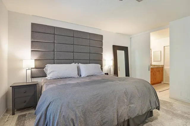 a large bed sitting in a bedroom and lamp