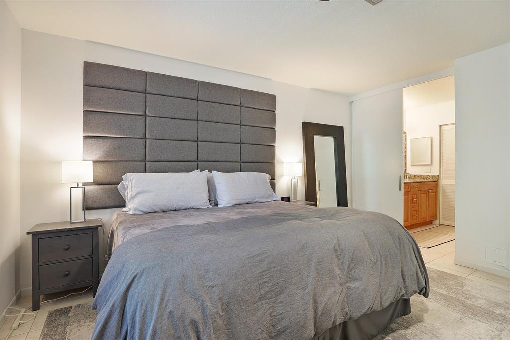 1141 Calamondin Terrace, Unit 202 Delray Beach, FL 33445 - Photo 14 of 19 a large bed sitting in a bedroom and lamp