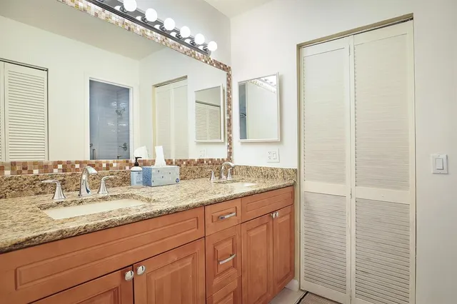 a bathroom with a granite countertop sink and a mirror