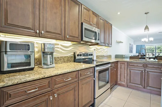 a kitchen with granite countertop stainless steel appliances a sink and cabinets