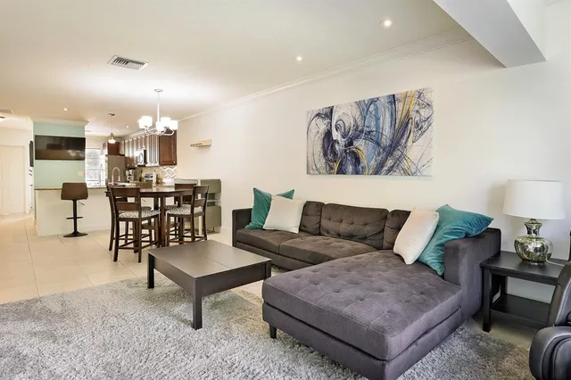 a living room with furniture and kitchen view