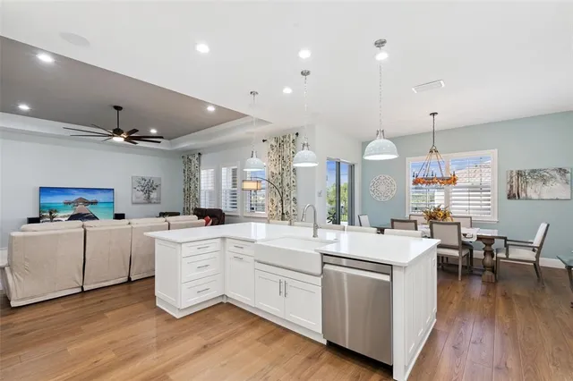 a kitchen with stainless steel appliances granite countertop a sink a stove and a wooden floors