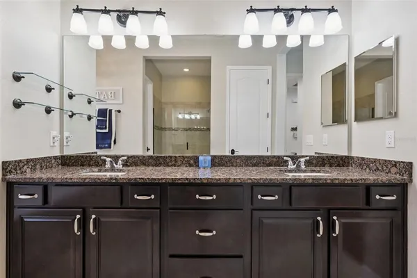 a bed sitting in a bedroom next to a window and a chandelier