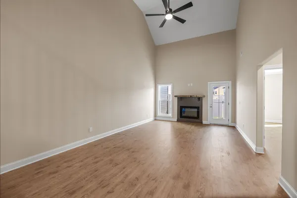 a view of empty room with wooden floor fireplace and window