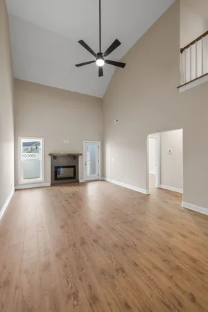 a view of empty room with wooden floor and a ceiling fan
