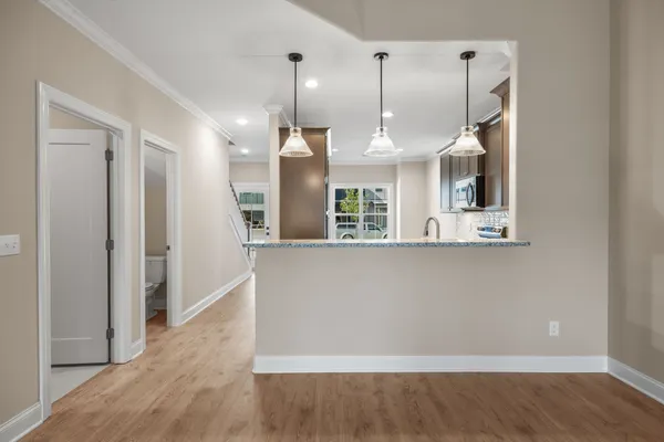 a view of kitchen and hall with wooden floor