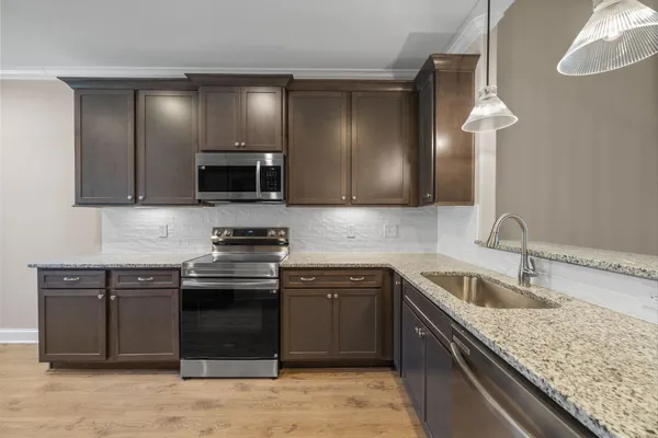 a kitchen with stainless steel appliances granite countertop a sink and a stove top oven