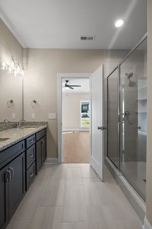 a bathroom with a granite countertop sink mirror and shower