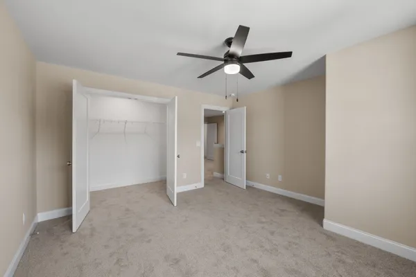 a view of a livingroom with a ceiling fan & window