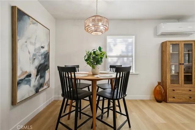 a view of a dining room with furniture a chandelier and wooden floor