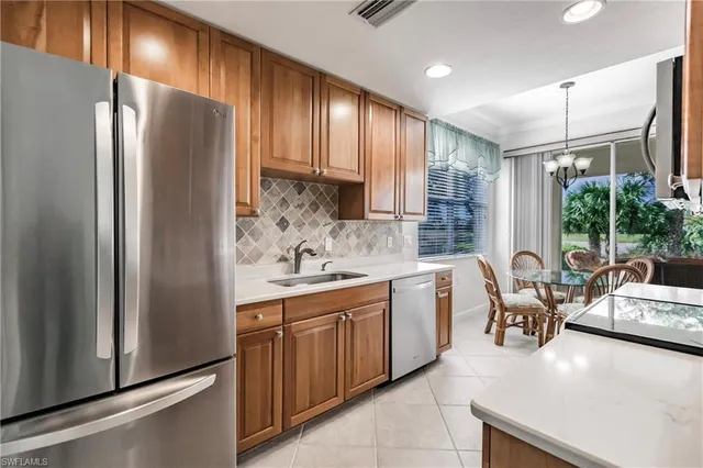 a kitchen with stainless steel appliances granite countertop a refrigerator and a sink