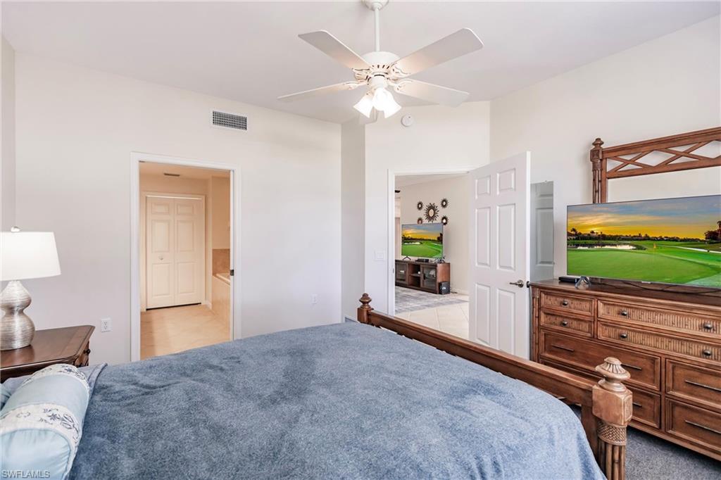 3071 Meandering Way, Unit 101 Fort Myers, FL 33905 - Photo 18 of 49 a bedroom with a bed and a flat screen tv