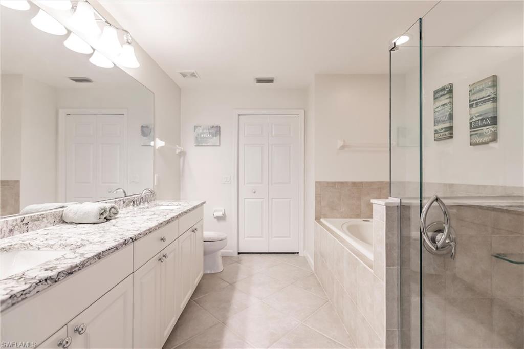 3071 Meandering Way, Unit 101 Fort Myers, FL 33905 - Photo 19 of 49 a spacious bathroom with a granite countertop sink a mirror and a bathtub