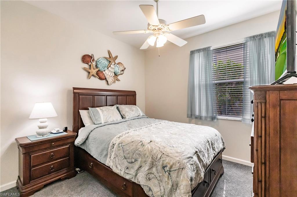 3071 Meandering Way, Unit 101 Fort Myers, FL 33905 - Photo 22 of 49 a bedroom with a bed and a chandelier