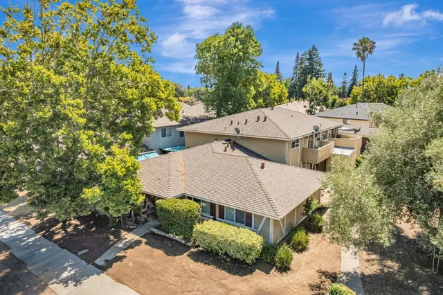 an aerial view of a house with a yard and large trees