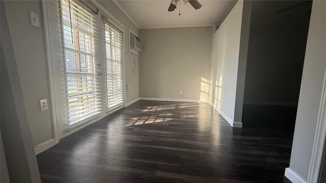 a view of empty room with wooden floor and fan