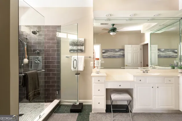 a bathroom with a granite countertop sink a toilet and shower