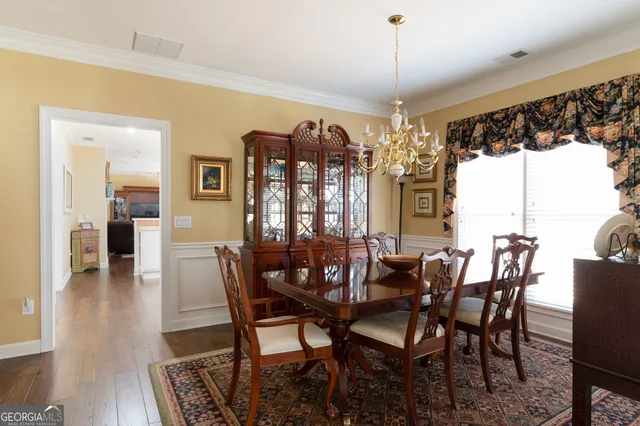 a view of a dining room with furniture wooden floor and chandelier