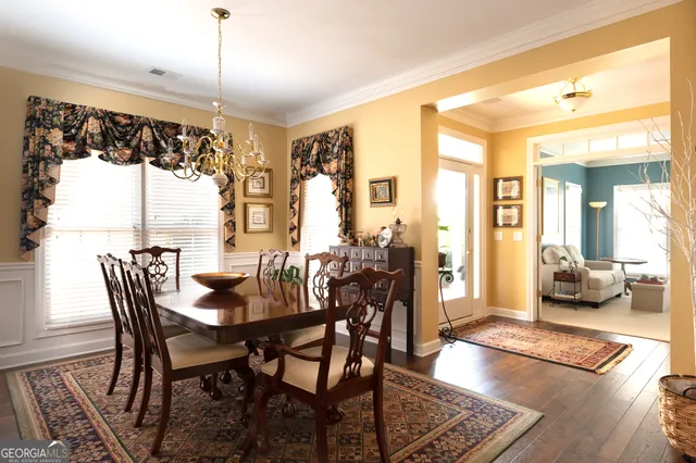a view of a dining room and livingroom with furniture wooden floor a chandelier