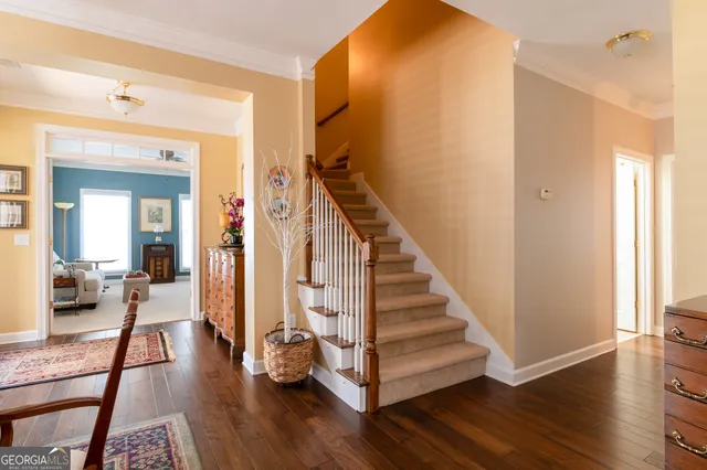 a view of a hallway with wooden floor and stairs