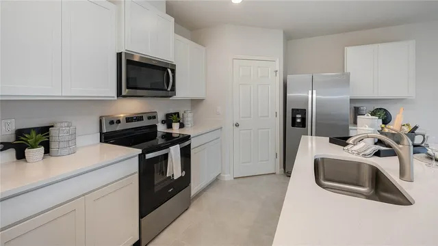 a kitchen with stainless steel appliances granite countertop a sink a stove a microwave and cabinets