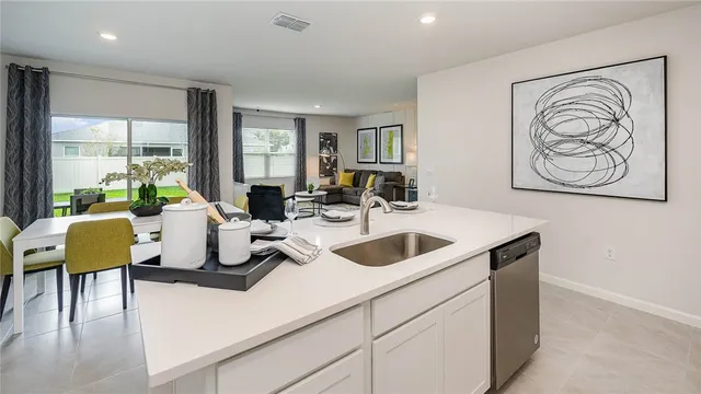 a kitchen with a sink a counter top space stainless steel appliances cabinets and a window