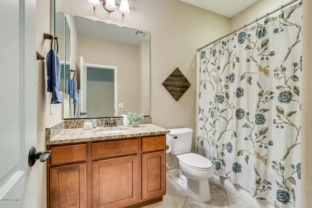 a bathroom with a granite countertop sink toilet mirror and shower