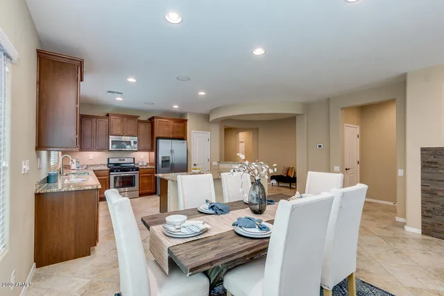 a dining room with wooden floor a glass table and chairs