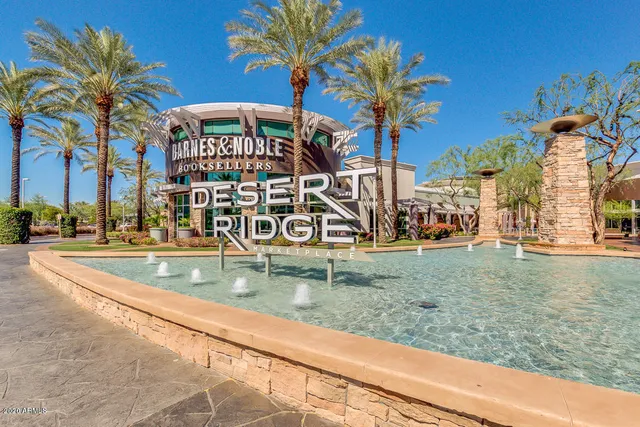 a view of swimming pool with a yard and palm trees