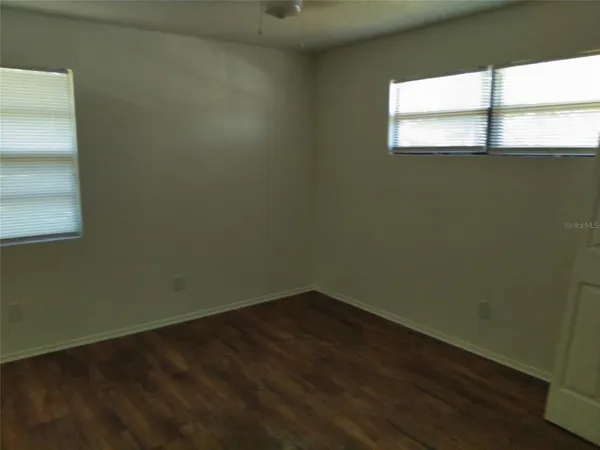 a view of a small space with wooden floor and a window