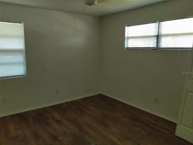 a view of a small space with wooden floor and a window