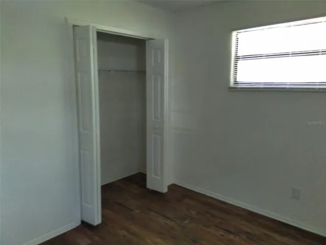 an empty room with wooden floor and a window