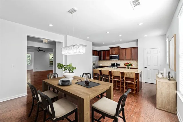 a kitchen with granite countertop a sink chairs and refrigerator