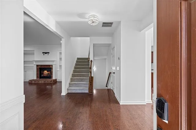 a view of empty room with wooden floor and fireplace