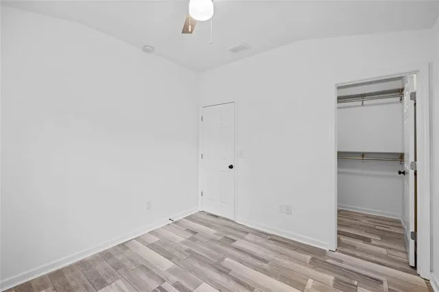 a view of an empty room with a window and closet