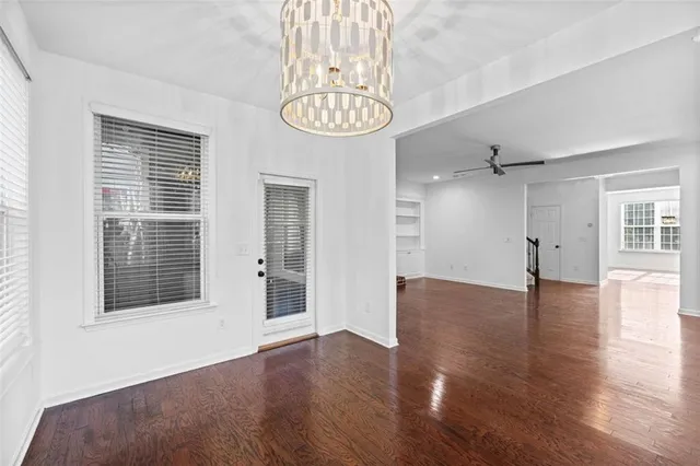 a dining room with furniture a chandelier and wooden floor