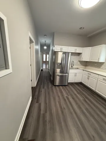a kitchen with cabinets and wooden floor
