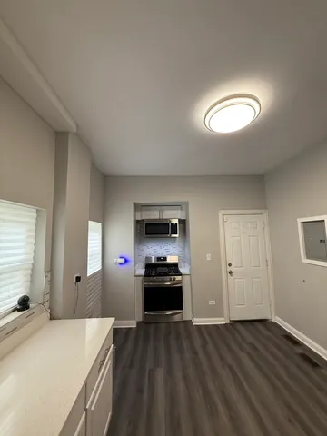a kitchen view with wooden floor and outdoor space