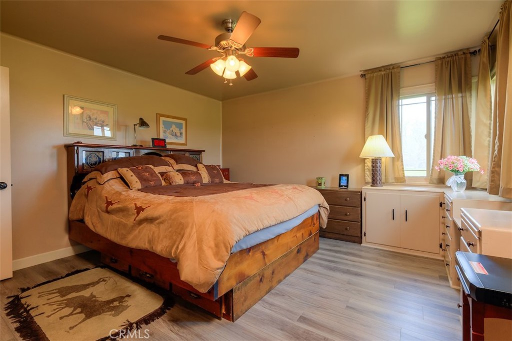 23256 Richfield Road Corning, CA 96021 - Photo 18 of 60 a bedroom with a bed and a chandelier