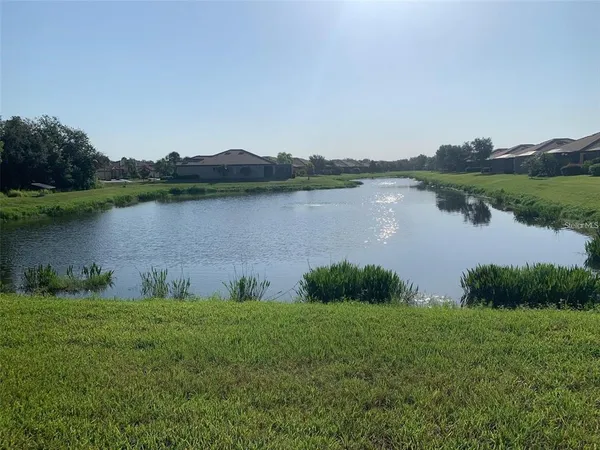 a sign board with a small yard and palm trees