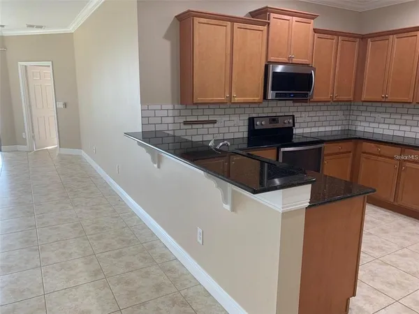 a kitchen with granite countertop a sink and a stove top oven
