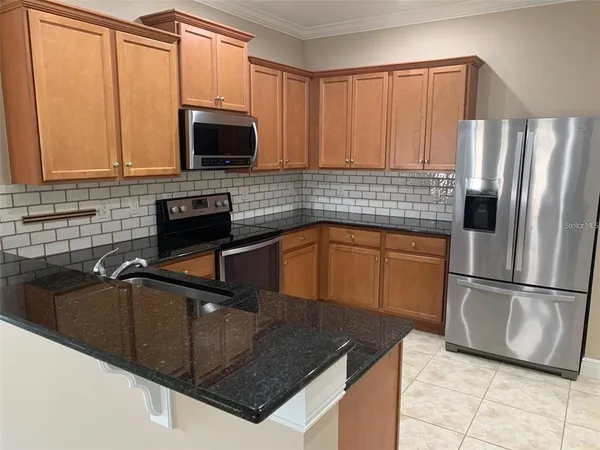a kitchen with stainless steel appliances granite countertop a sink stove and microwave