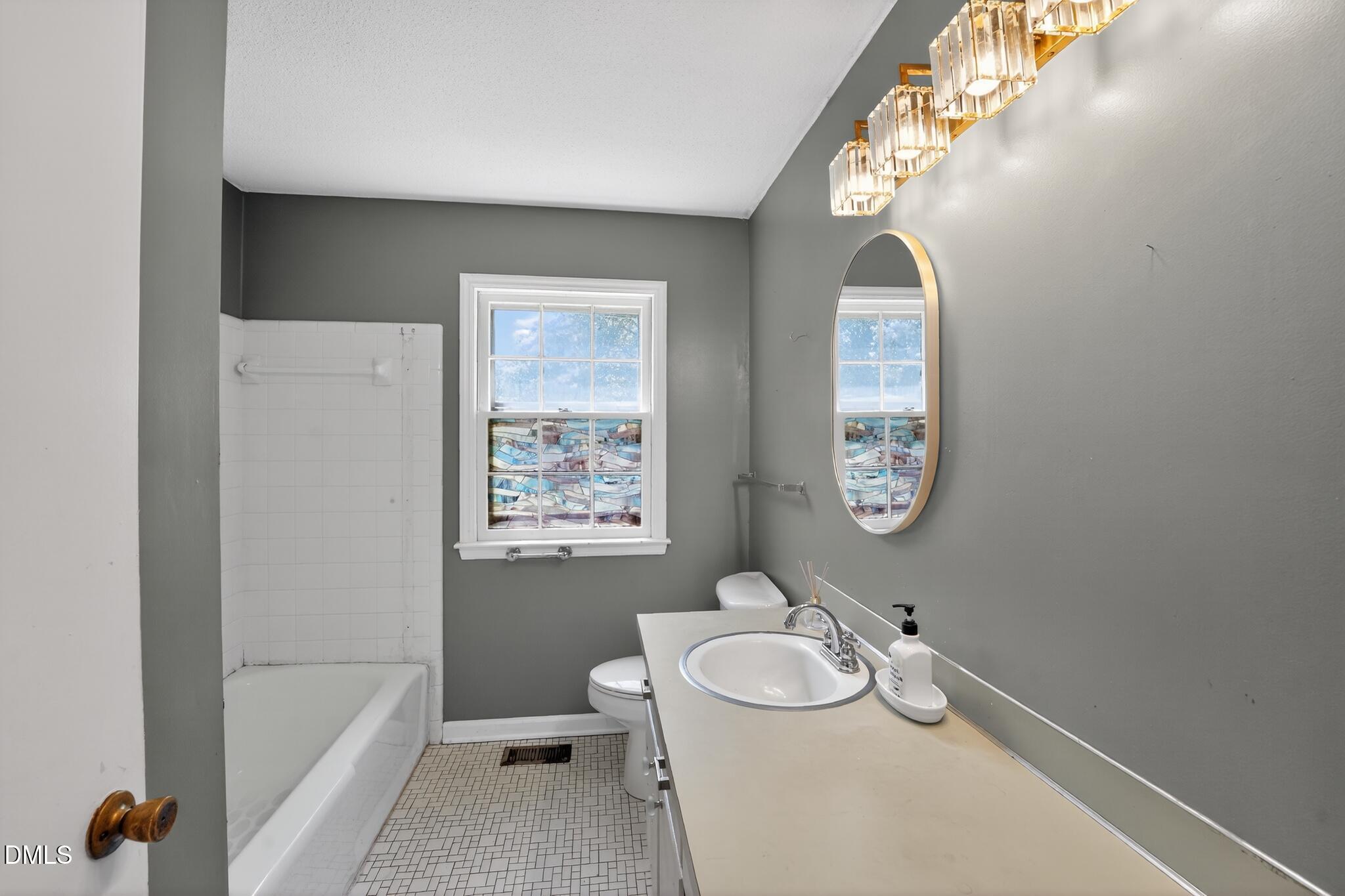 1034 Jerome Road Durham, NC 27713 - Photo 30 of 35 a bathroom with a sink a toilet and shower