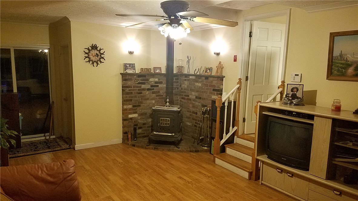 163 Burnt Hill Road Scituate, RI 02831 - Photo 19 of 24 Family room with wood stove and sliders to sunroom and rear yard.