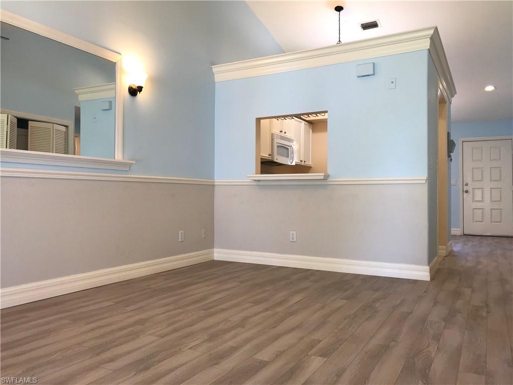 157 Wading Bird Circle, Unit K205 Naples, FL 34110 - Photo 11 of 22 a view of a hallway with wooden floor